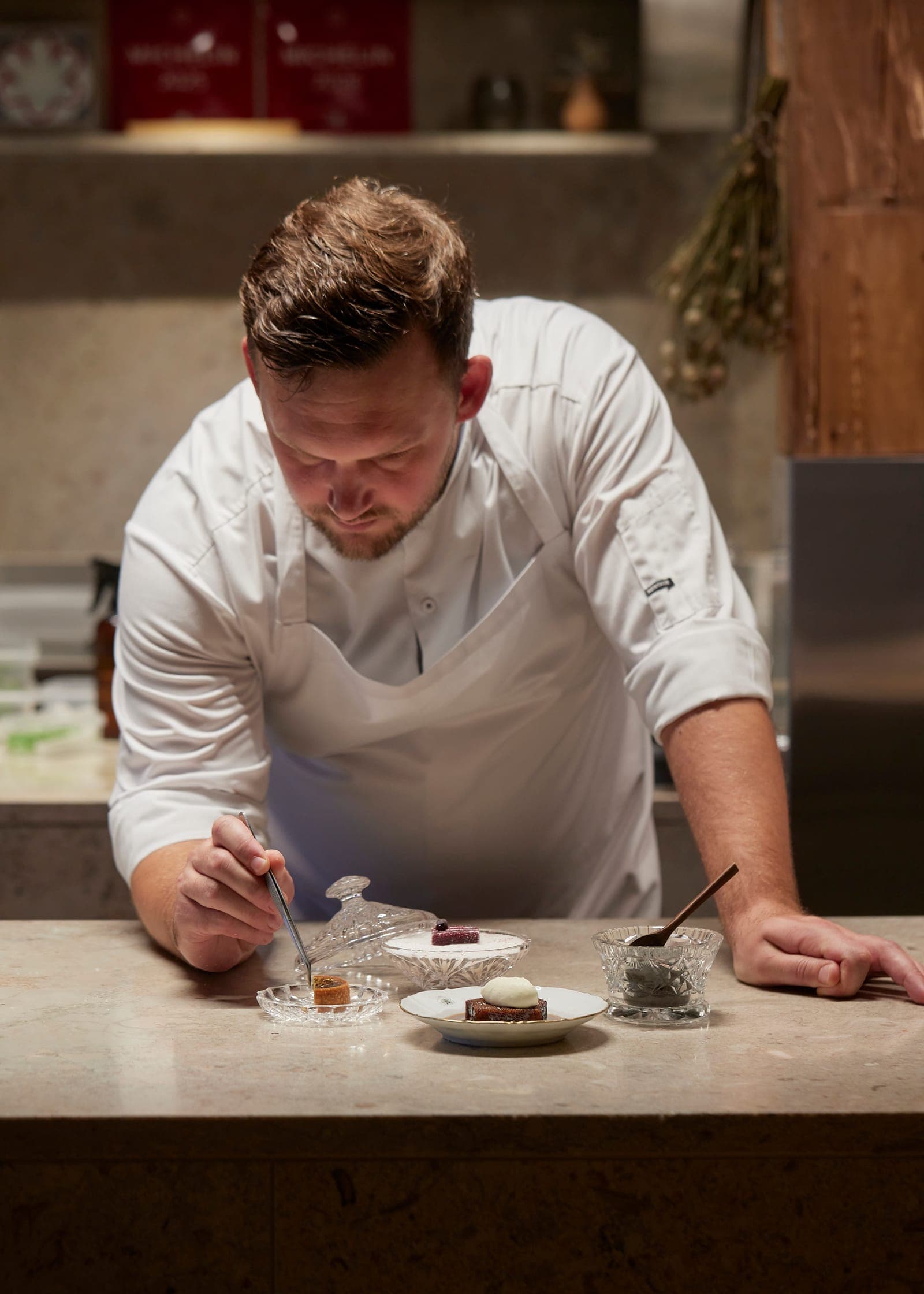 Nicky Arentsen finishing a dish at the kitchen counter